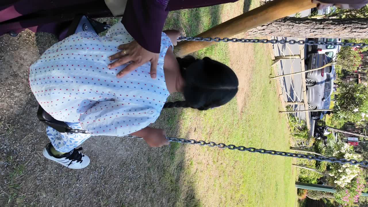 A child playing on a swing in a park