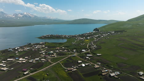 Vibrant-blue-Tabatskuri-lake-and-rural-village,-located-far-from-urban-world