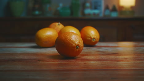 person picking up oranges from a wooden table