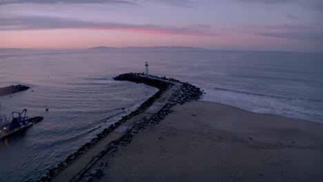 farol del puerto de santa cruz, california, con un avión no tripulado acercándose desde el puerto al amanecer