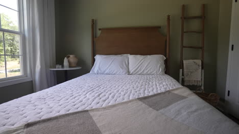 newly renovated bedroom has a clean bed with a wooden headboard in a farmhouse decorated design