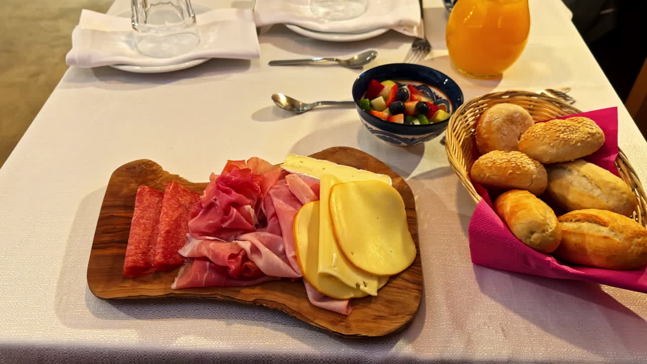 Salumi e formaggi italiani su tagliere di legno, cena accogliente a Trieste