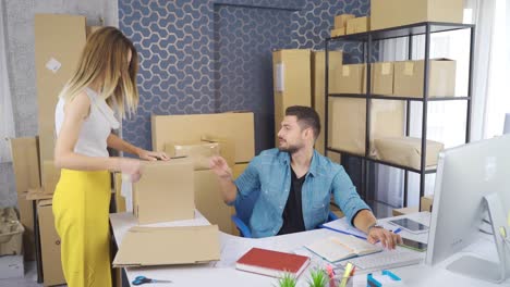 mujer y hombre empresarios empaquetando cajas, vendiendo a través del comercio electrónico.