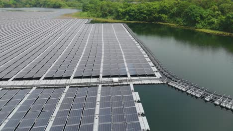 Aerial view of floating solar panels installed on the surface of a lake in Sungai Rawang, Serendah, Malaysia. The large grid of photovoltaic panels rests on buoyant structures, bordered by calm water