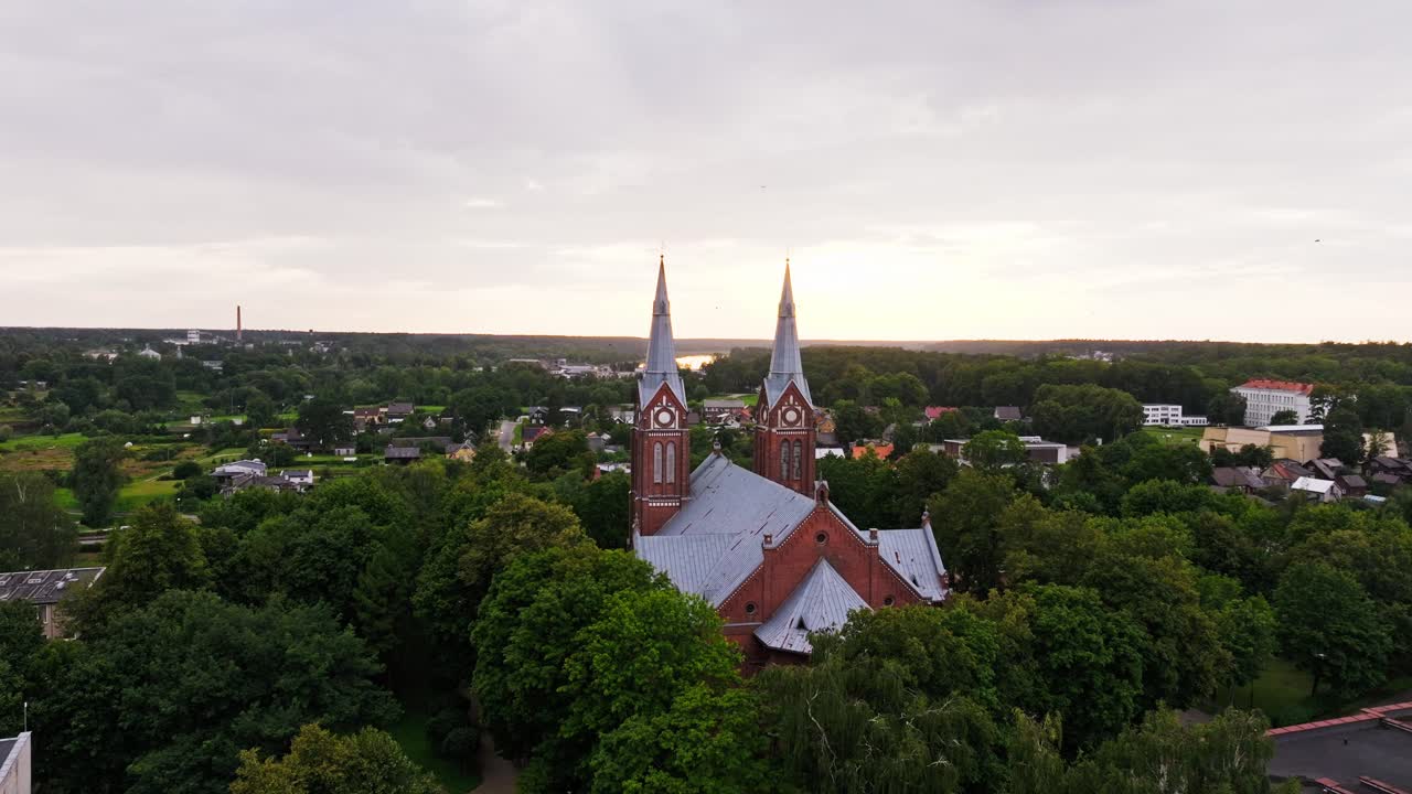 Cinematic drone orbit of Jurbarkas Catholic Holy Trinity church at sunset view