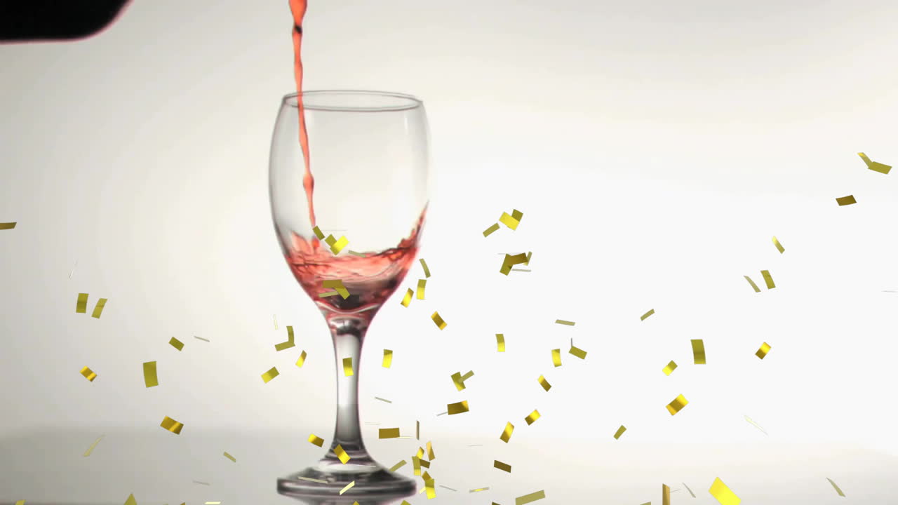 Animation of confetti over glass of red wine on white background