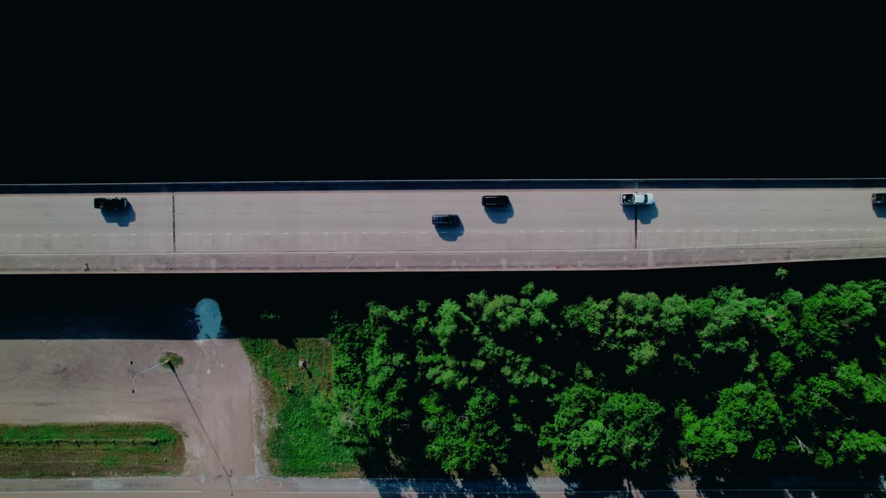 Top down aerial of vehicles driving across bridge over water in Louisiana. Bridge over wetlands