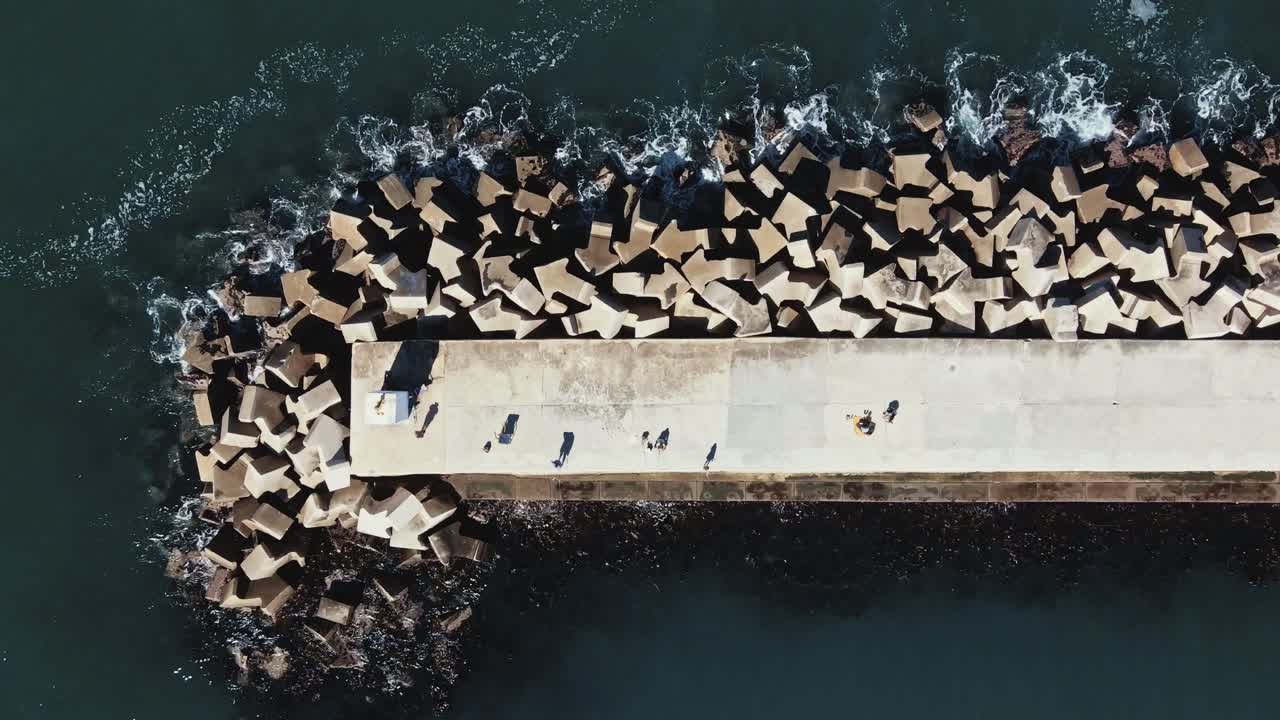 A large, concrete dock and breakwater as seen directly from above