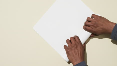 video de las manos de un hombre afroamericano con papel blanco enrollado sobre un fondo blanco