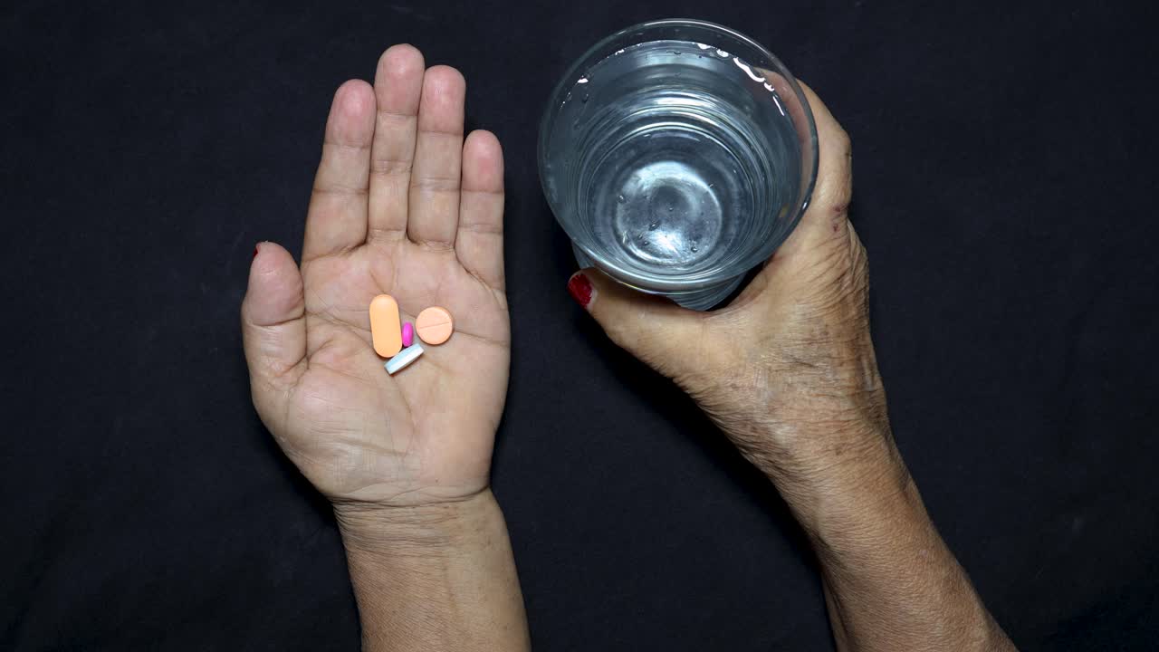 old age health care concept with medicine and water glass