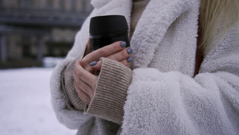 blonde girl holding hot thermos