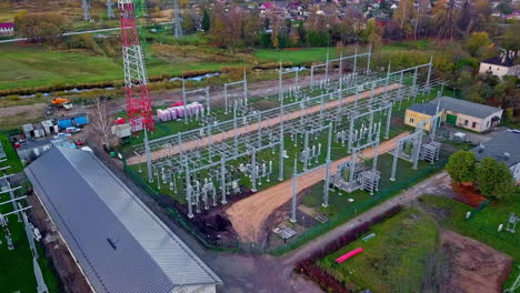 aerial drone forward moving shot taken over a high voltage power distribution substation at daytime