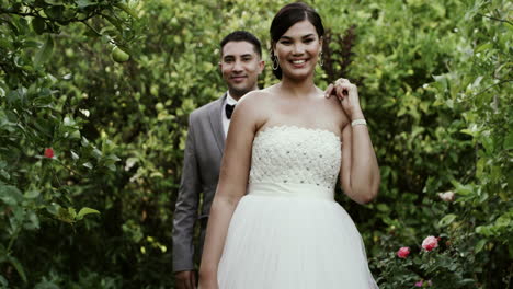 couple posing in a garden on their wedding day