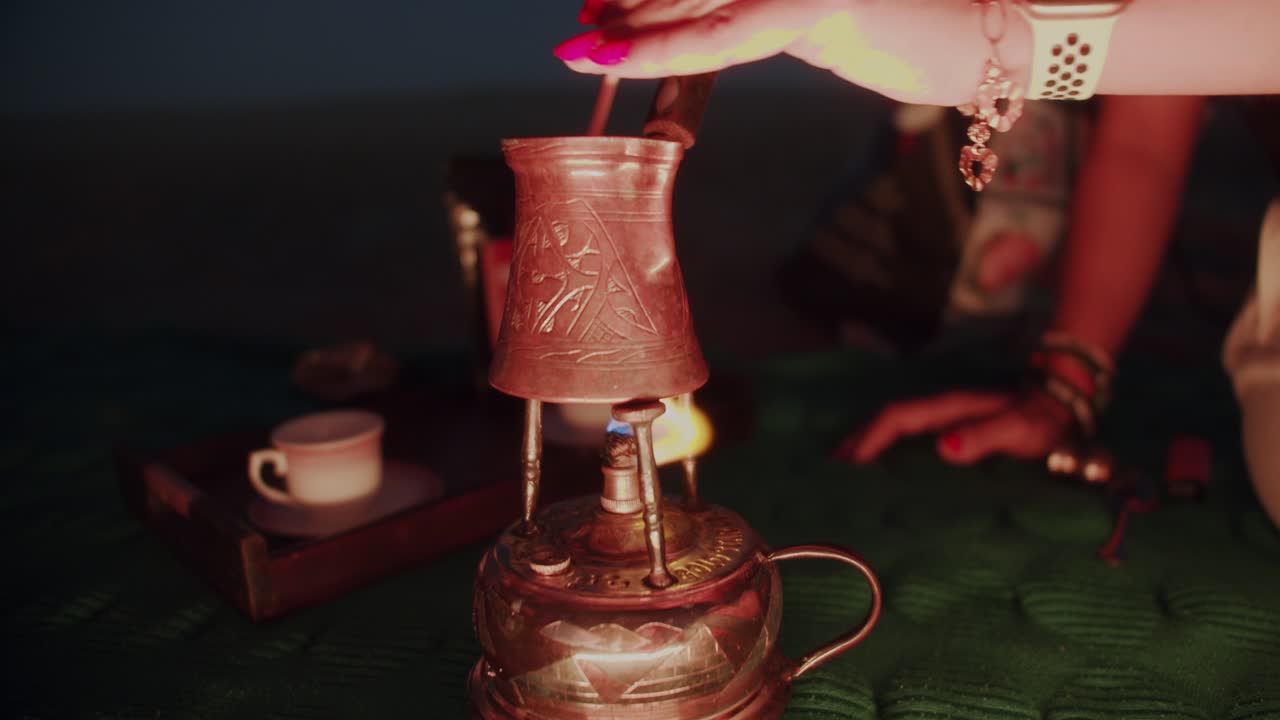 Hands of girl cooking boiling delicious Turkish aromatic coffee with foam in copper pot. Coffee preparation.