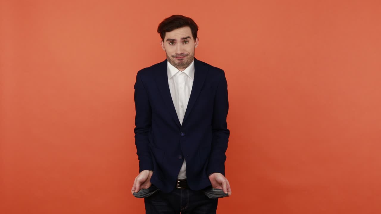 걱정하는 남자는 돈이 없는 빈 바지 주머니를 보여줍니다.