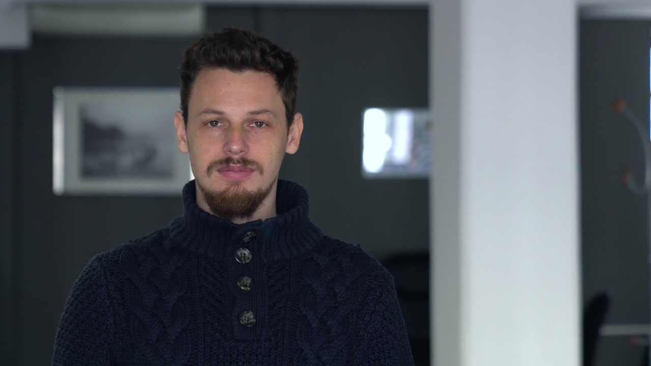 Uomo che si gira verso la telecamera, poi sta fermo per un po' e la guarda