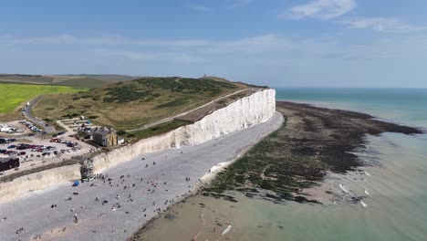 brlington gap of seven sisters , white cliffs english south coast drone view blue sky crowded beach