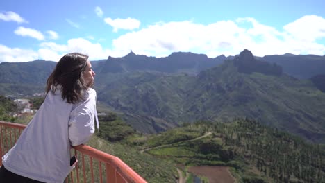 woman looking at mountains landscape at viewpoint in artenara, gran canaria, spain