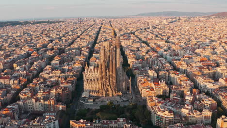 rising pan down drone shot of la sagrada familia basilica barcelona at sunrise