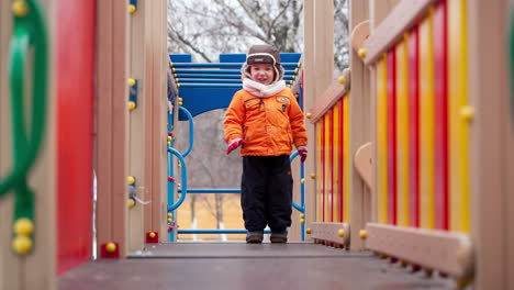 niño pequeño en el equipo de parque infantil