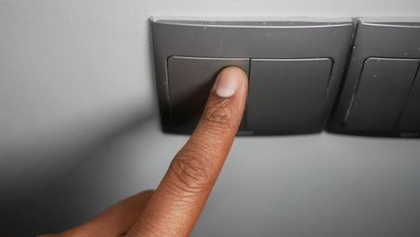 el dedo presionando un interruptor de luz