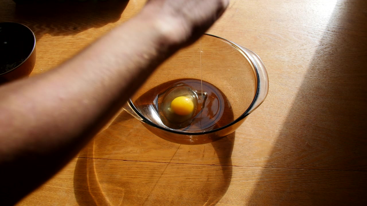 Cracking An Egg And Putting It Into A Bowl