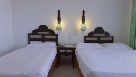 zooming shot of two single beds in classic bedroom under suspended lights