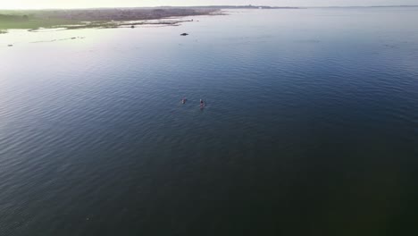 un brillante día de verano con dos personas en kayak en un océano azul profundo