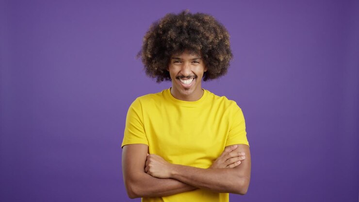 Man with Afro and Yellow Shirt Smiling with Arms Crossed