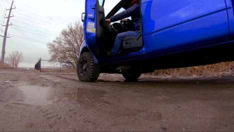 man getting out of a truck or large vehicle stepping in a puddle - slow motion