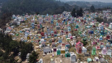 Low-flight-to-colorful-family-crypts-in-hillside-cemetery-of-Guatemala