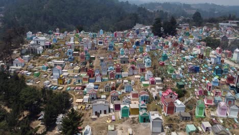 low flight to colorful family crypts in hillside cemetery of guatemala