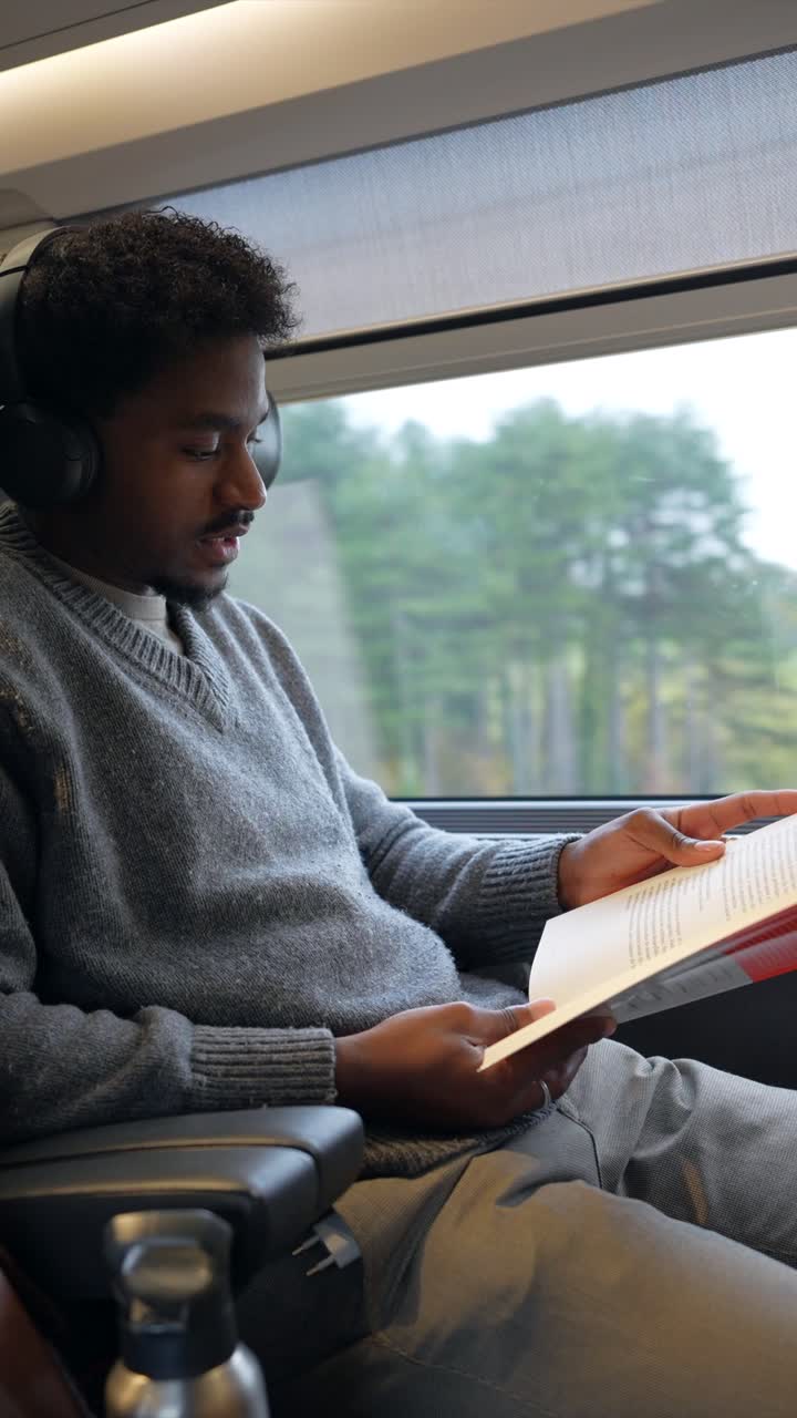Un homme lisant un livre dans un train