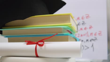 completion of university studies during a pandemic. books, a higher education diploma, a graduate hat and a protective medical mask spin on a stand