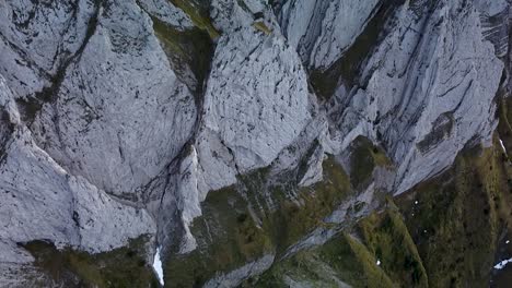 Beautiful-aerial-look-up-to-high-mountain-summit,-steep-rocky-ridge