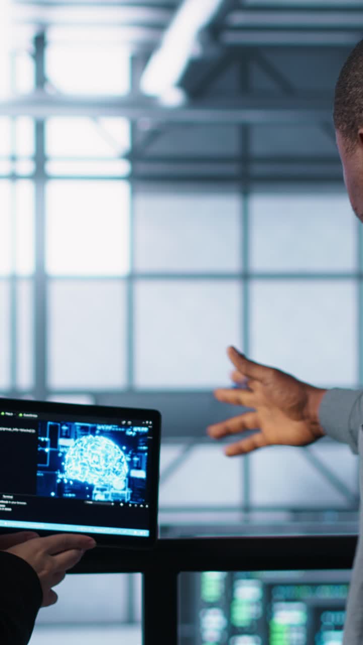 Vertical video Software developers in data center use AI technology on tablet