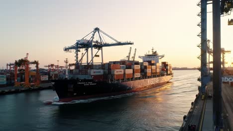 a cargo ship navigating through a busy port at sunset, capturing the essence of maritime trade and logistics in a colorful, dynamic environment