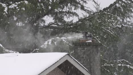 humo de chimenea de piedra que sopla en el viento durante una fuerte nevada en invierno