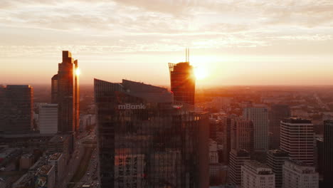 Slider-Eines-Modernen-Bürohochhauses-Und-Einer-Gruppe-Von-Wolkenkratzern-In-Der-Innenstadt-Im-Hintergrund-Gegen-Helle-Sonne.-Warschau,-Polen