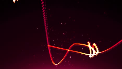 Animation-of-orange-and-red-light-trails-and-particles-moving-on-black-background