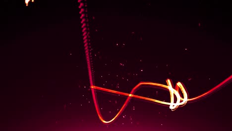 animation of orange and red light trails and particles moving on black background