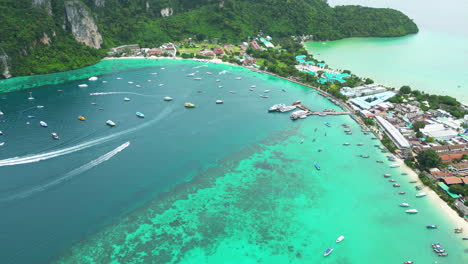 Tropical-town-with-boats-and-magical-bays-surrounding,-aerial-drone-view