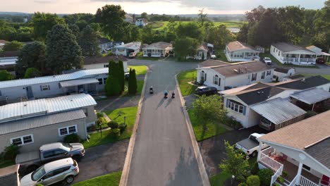 elderly women ride jazzy scooter wheelchairs outside through old income housing rural mobile home park in usa