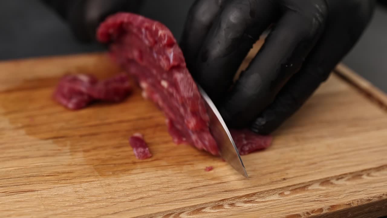 Cutting beef steak on a wooden board
