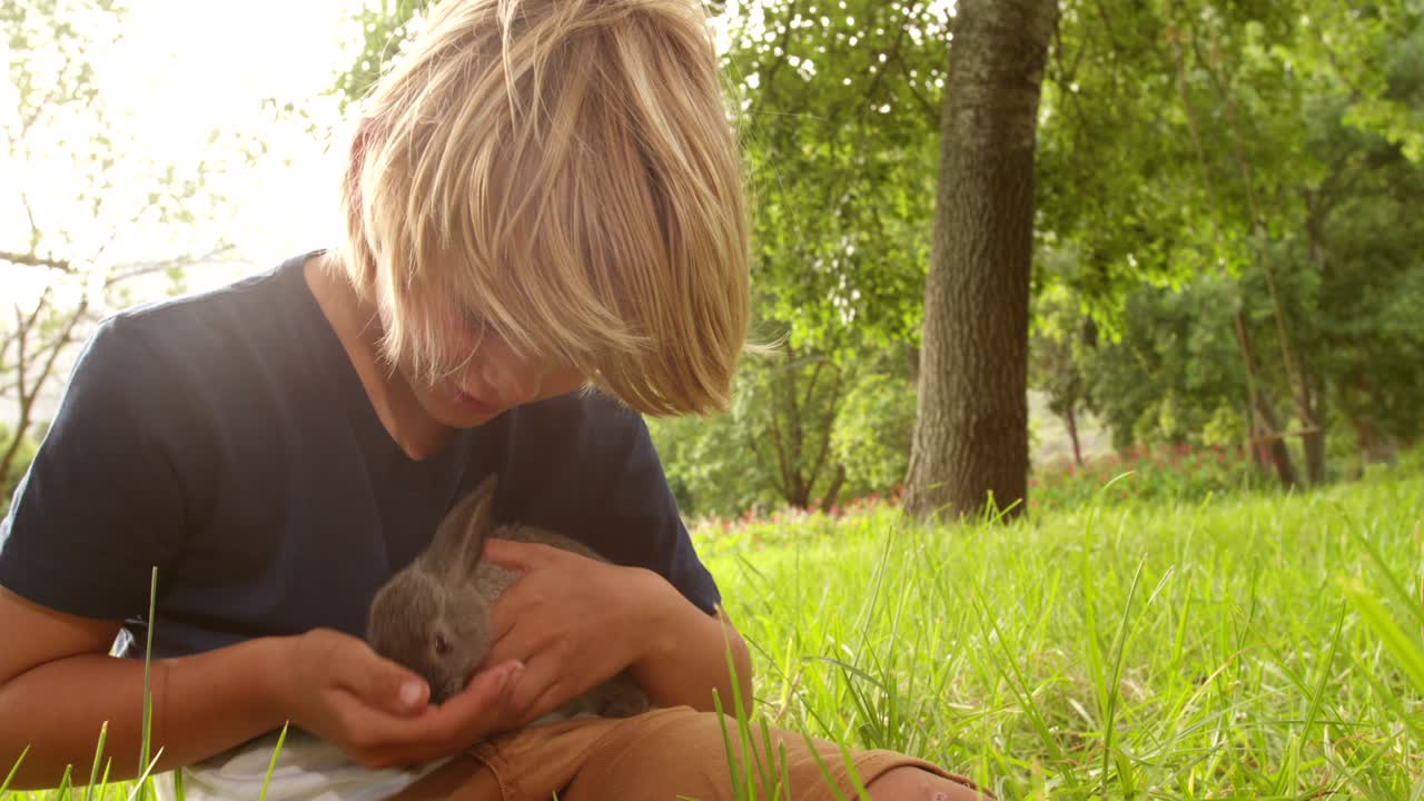 밖에서 토끼를 돌보는 행복한 아이