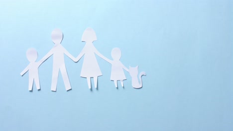 close up of family with cat made of white paper on blue background with copy space