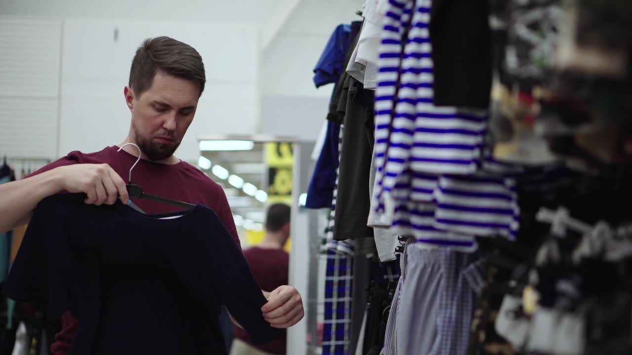 Homem experimentando roupas em uma loja de roupas