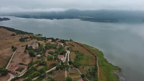 Pueblo-De-Nanclares-De-Gamboa-En-El-País-Vasco,-España,-Con-Un-Lago-Brumoso-Como-Telón-De-Fondo,-Vista-Aérea