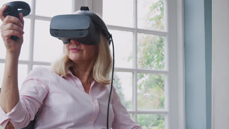 Reife-Behinderte-Frau-Im-Rollstuhl-Zu-Hause-Mit-Virtual-Reality-Headset-Gaming-Controllern