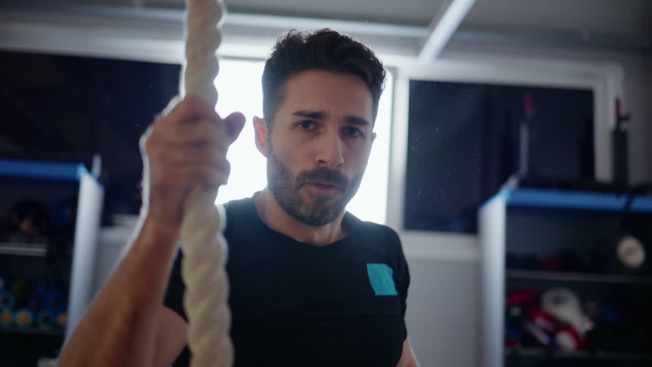 Treino de atleta: escalando uma corda em uma academia, com foco em força e resistência durante uma sessão de fitness para aprimoramento físico e domínio de habilidades